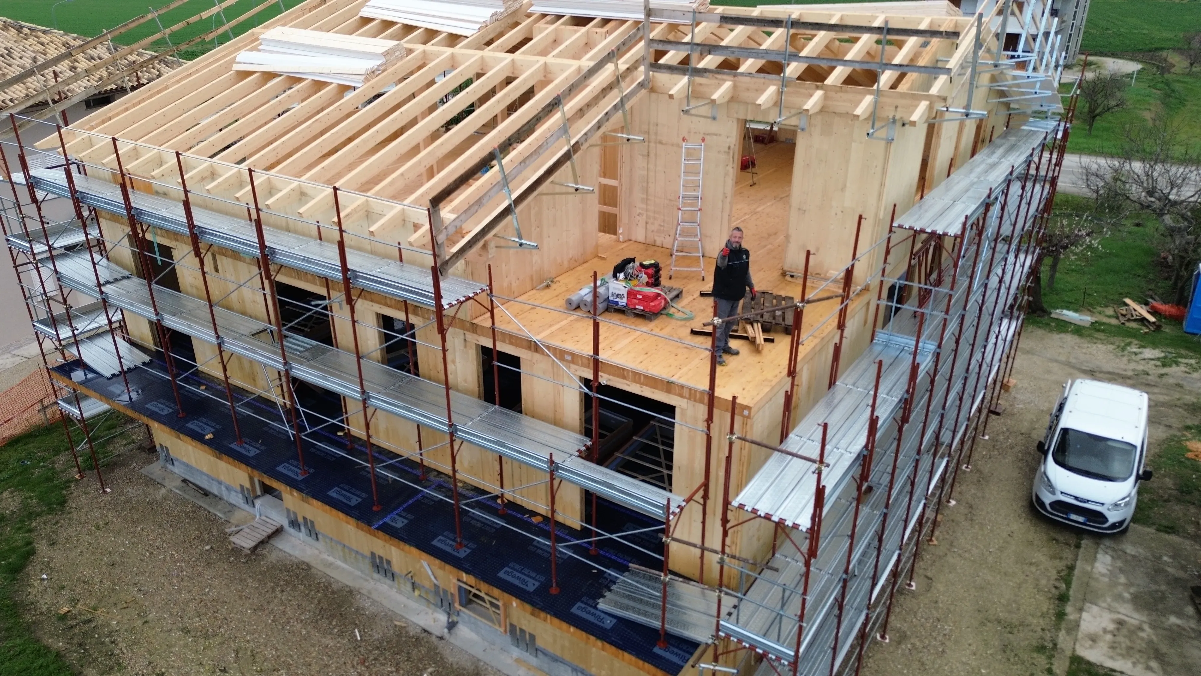 Casa in legno in cantiere con cartello lavori — incentivi fiscali 2026